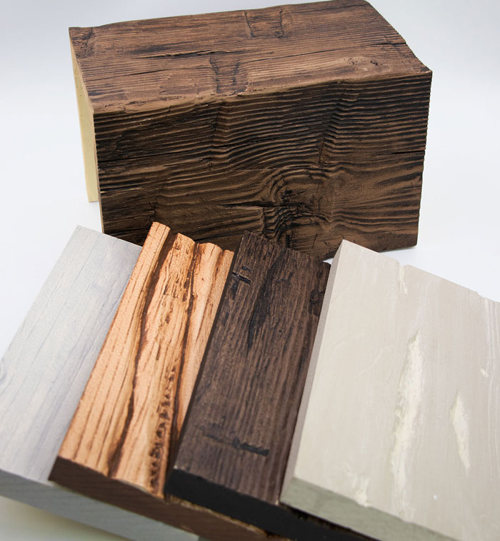 Faux Wood beam samples on a table showing both made to order beams and quick ship beams.