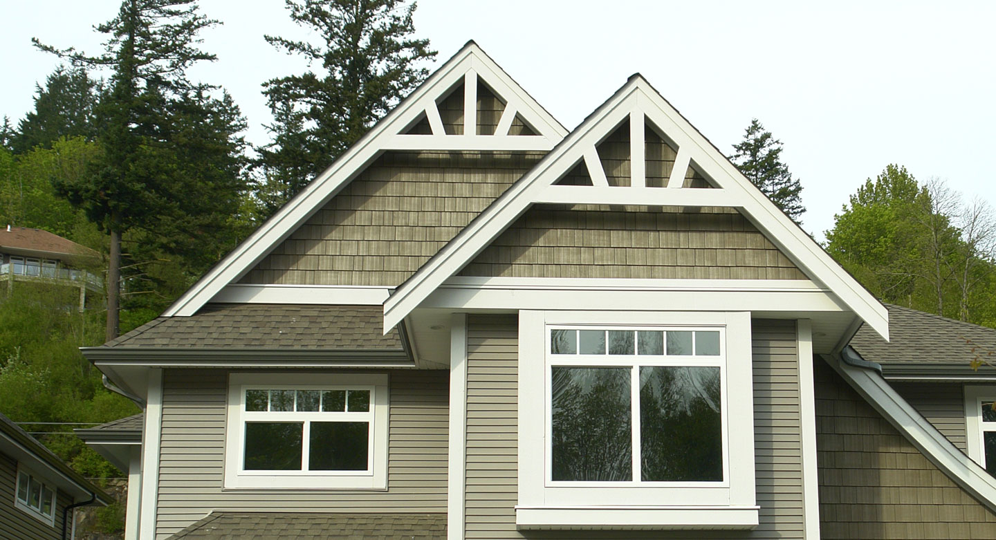 A green modern home with vinyl siding. Under the roof there is a urethane gable bracket attached.